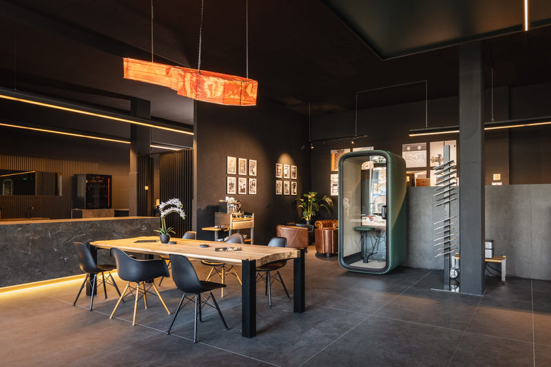 Lounge mit Holztisch und Kupferleuchte im azado Showroom Wittenbach